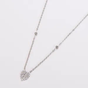 Detail van zilveren roestvrijstalen ketting met hol blad hangertje en strass-steentjes