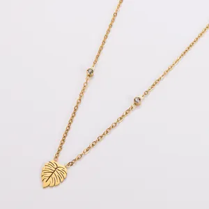 Detail van vergulde roestvrijstalen ketting met hol bladhanger en kristallen accenten