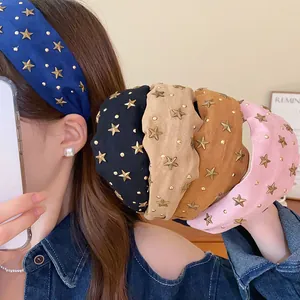 Detalle de diademas anchas con estrellas en varios colores usadas por modelo