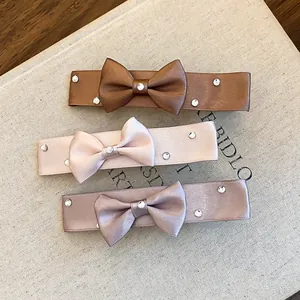 Set of three elegant satin ribbon bow hair clips with rhinestones in soft neutral colors