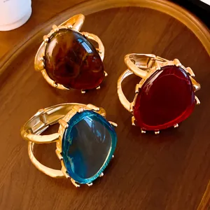 Nahaufnahme von übertriebenen Harz-Dreiecksarmreifen mit goldfarbenem Klickverschluss.