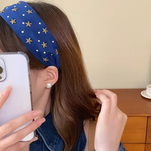 Primer plano de una diadema ancha de tela azul con estrellas doradas en una modelo