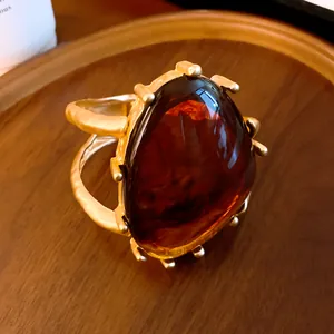 Detail eines klobigen Gold-Armreifs mit großem dreieckigem Bernstein-Harzstein.