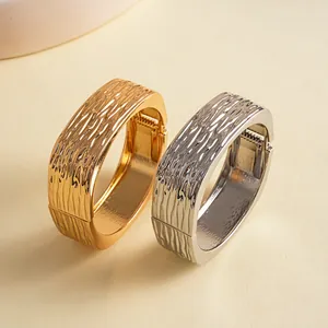 Gedetailleerde close-up van gouden en zilveren vierkante armbanden met rimpeltextuur
