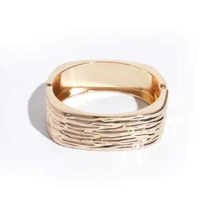 Moderne minimalistische goudkleurige vierkante armband met een unieke geplooide textuur