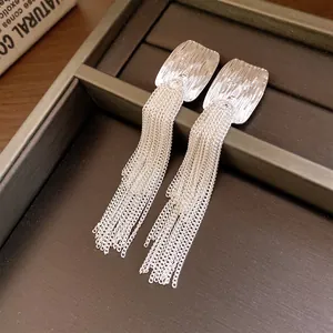 Close-up of French style wrinkled square silver earrings with long double-layer chain tassels.
