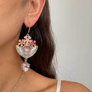 Detailopname van een vintage ketting met roze bloem, engel en hart bij een model