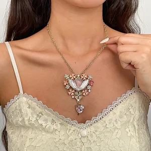 Detail van een vintage engel-ketting met roze bloemen en schitterende strassteentjes