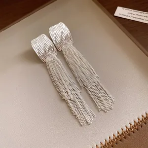Close-up of silver square textured earrings featuring elegant long tiered chain tassels