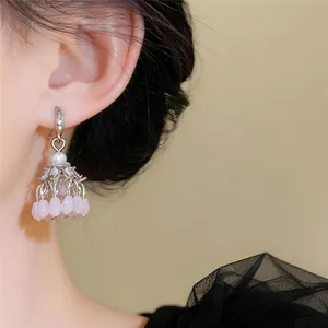 Close-up view of ethnic style zircon tassel earrings featuring pink lily of the valley beads