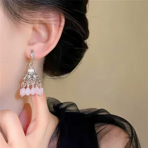 Detailed shot of ethnic zircon tassel earrings with pink natural stones on female model