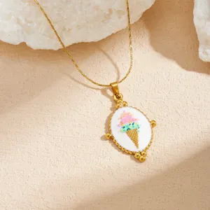 Detailed close-up of a gold plated stainless steel oval enamel pendant with colorful ice cream