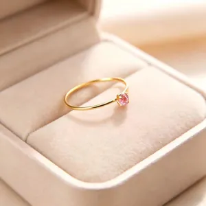 Detailansicht eines 1 mm dünnen vergoldeten Rings mit einem funkelnden rosa Zirkon.