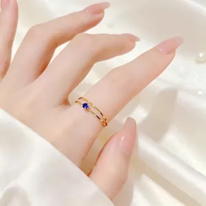 Nahaufnahme eines 1 mm vergoldeten Titanrings mit einem strahlend blauen Zirkonia-Stein