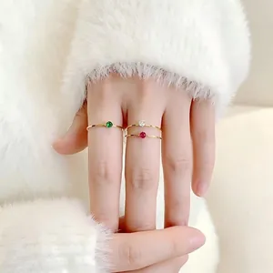 Detailansicht von 1 mm ultradünnen vergoldeten Ringen mit bunten Edelsteinen an der Hand