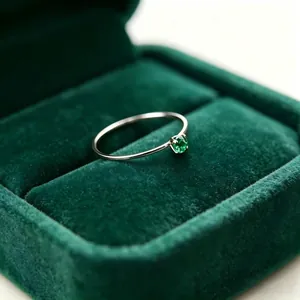 Nahaufnahme eines 1mm dünnen Titanstahlrings mit grünem Zirkon in einer Vier-Krallen-Fassung.