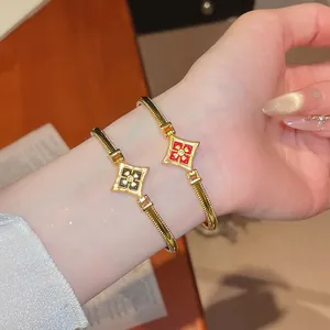 Gros plan détaillé de bracelets fleurs plaqués or 24K avec incrustation d'émail rouge.