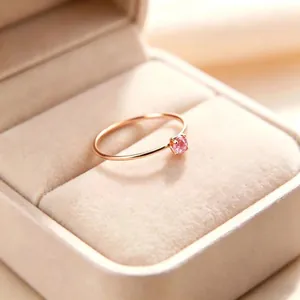 Detailansicht eines feinen 1mm Titanstahlrings mit funkelndem rosa Zirkonia-Stein
