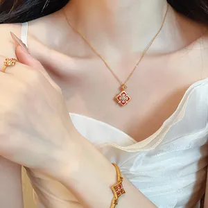 Gros plan d'une parure de bijoux à motif de fleurs dorées avec collier, bracelet et bague