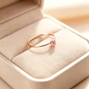 Nahaufnahme eines 1mm Titanstahlrings mit funkelndem rosa Zirkon in Roségold