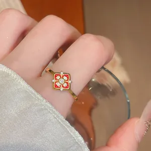 Gros plan détaillé d'une bague plaquée or avec un motif de fleur en zircon rouge vif