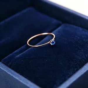 Detaillierte Ansicht eines 1mm dünnen Roségoldrings mit blauem Zirkonia in Samtbox