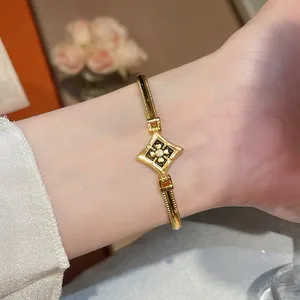 Gros plan élégant d'un bracelet plaqué or 24 carats avec breloque fleur en zircon en losange