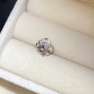 Gros plan d'une pierre ronde facettée dans une monture de boucle d'oreille en acier