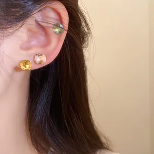 Gros plan de boucles d'oreilles en cristal multicolore portées pour un look élégant