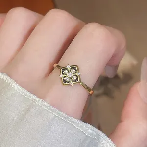 Gros plan détaillé d'une bague fleur plaquée or 24K avec zircons et incrustation émail noir