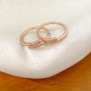 Minimalist gold-plated open rings with zircon stones displayed on white ceramic plate