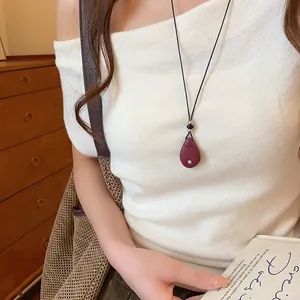 Minimalistische ketting met donkerrode waterdruppel hanger en zwart leren koordje