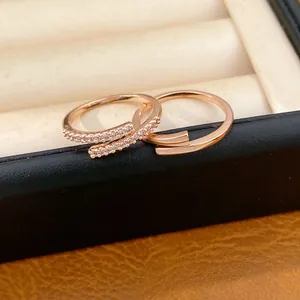 Détail de bagues ajustables en or rose avec zircons étincelants dans un écrin noir
