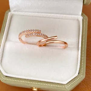 Gros plan de bagues ouvertes plaquées or rose avec zircones dans un écrin