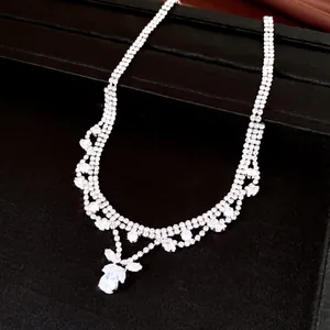 Close-up of sparkling zircon necklace with water-drop pendant on black background
