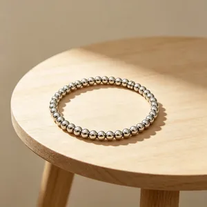Detailansicht eines 6mm Edelstahl-Perlenarmbands auf einer Holzoberfläche