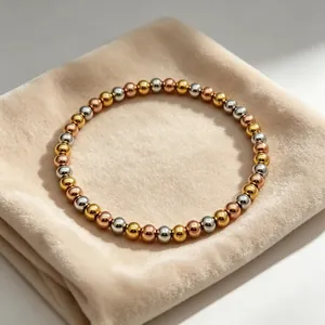 Detailaufnahme eines tricolor 6mm Perlenarmbands auf einem weichen beige Samtkissen