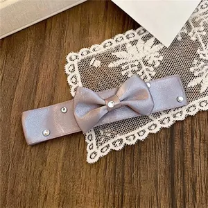 Nahaufnahme einer eleganten lavendelfarbenen Satinschleifen-Haarklammer mit Strasssteinen