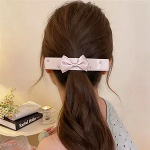 Eleganter rosa Schleifen-Haarclip mit glitzernden Strasssteinen im Pferdeschwanz