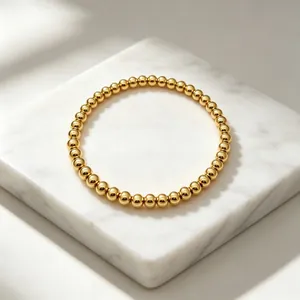Nahaufnahme eines 18K vergoldeten 6mm Perlenarmbands auf Marmor