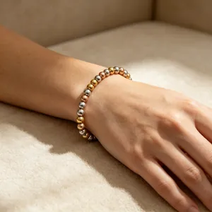 Nahaufnahme eines eleganten dreifarbigen 6mm Edelstahl-Perlenarmbands am Handgelenk