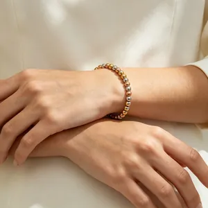 Detaillierte Nahaufnahme eines dreifarbigen Edelstahl-Perlenarmbands 6mm am Handgelenk