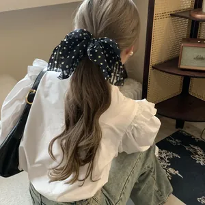Back view of a polka dot bow hair tie for a romantic Hepburn-style ponytail.
