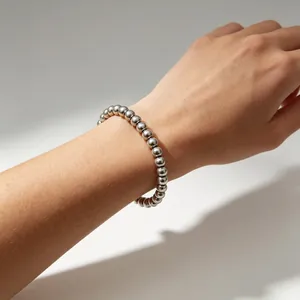 Klassisches silberfarbenes Edelstahl-Kugelarmband mit 6 mm Perlen an einem Handgelenk