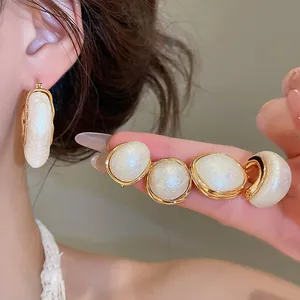 Elegante 18 Karat vergoldete Ohrringe mit weißen Baumwollperlen in der Nahaufnahme