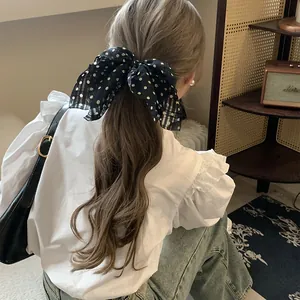 Back view of a woman wearing a chic navy blue polka dot bow hair tie for half-up hair