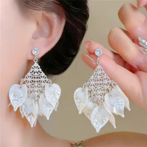Detailed view of forest-style acrylic leaf earrings with cat eye stones and silver posts.