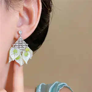 Close-up view of forest style acrylic petal earrings with green cat eye stone beads