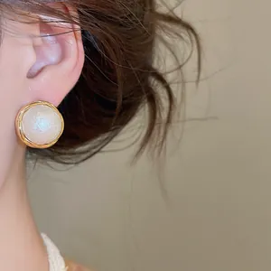Detailansicht eleganter Baumwollperlen-Ohrstecker mit hochwertiger 18 Karat Vergoldung