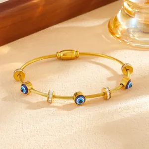Dettaglio del bracciale in acciaio inossidabile dorato con ciondoli malocchio e cristalli